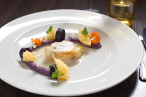 Nahaufnahme eines Tellers mit Fisch und weiteren Speisen in einem Restaurant in Heringsdorf