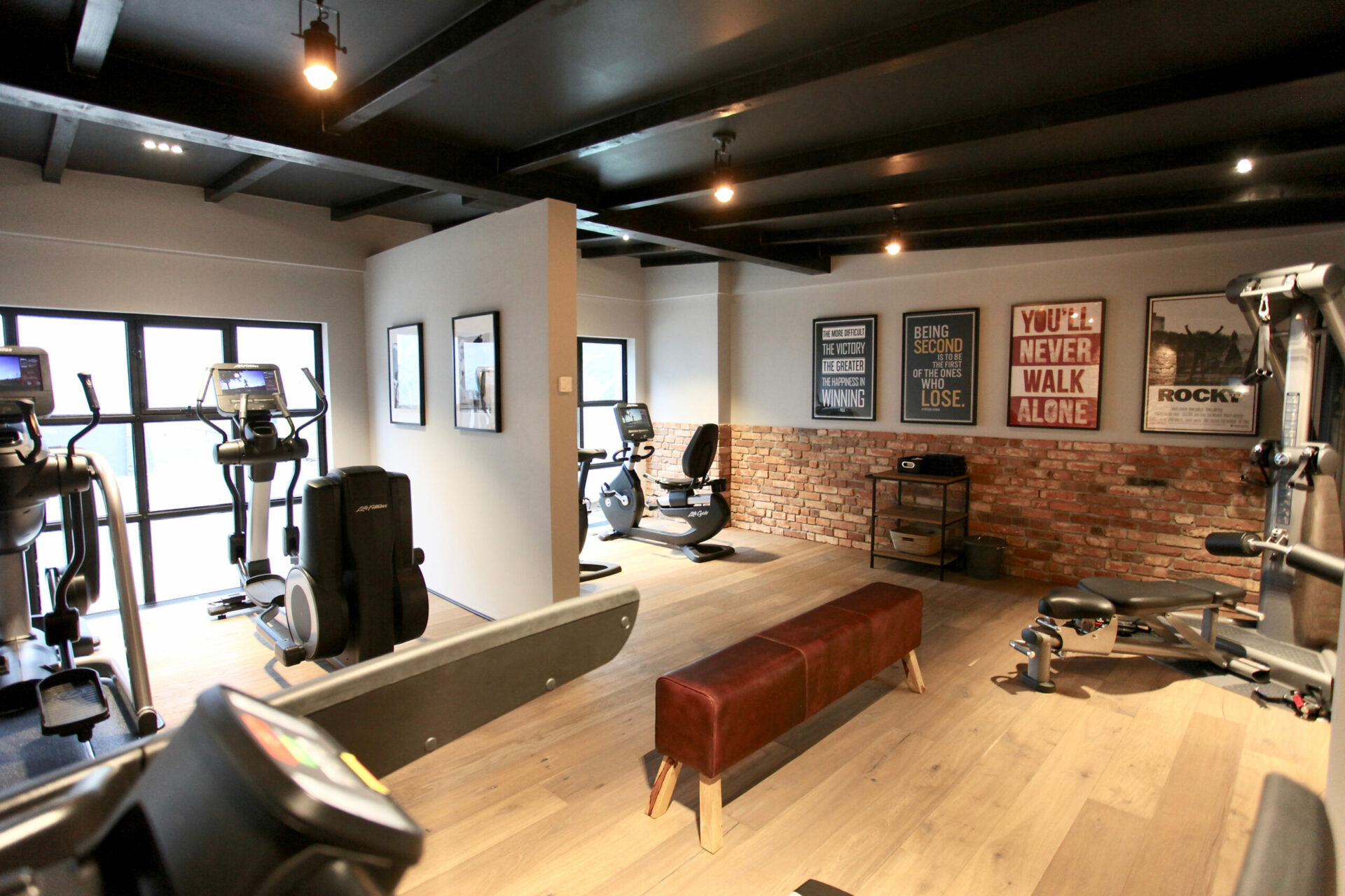 Foto von einem großen Fitnessstudio mit diversen Sportgeräten und Bildern an den Wänden in einem Hotel mit Sauna auf Usedom