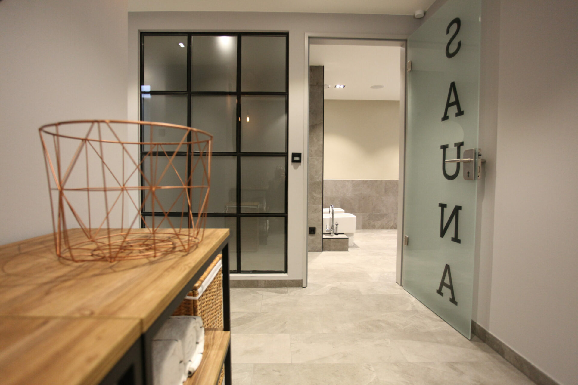 Aufnahme eines Regals mit Handtüchern und einer Tür zum Sauna-Eingangsbereich in einem Hotel mit Sauna auf Usedom