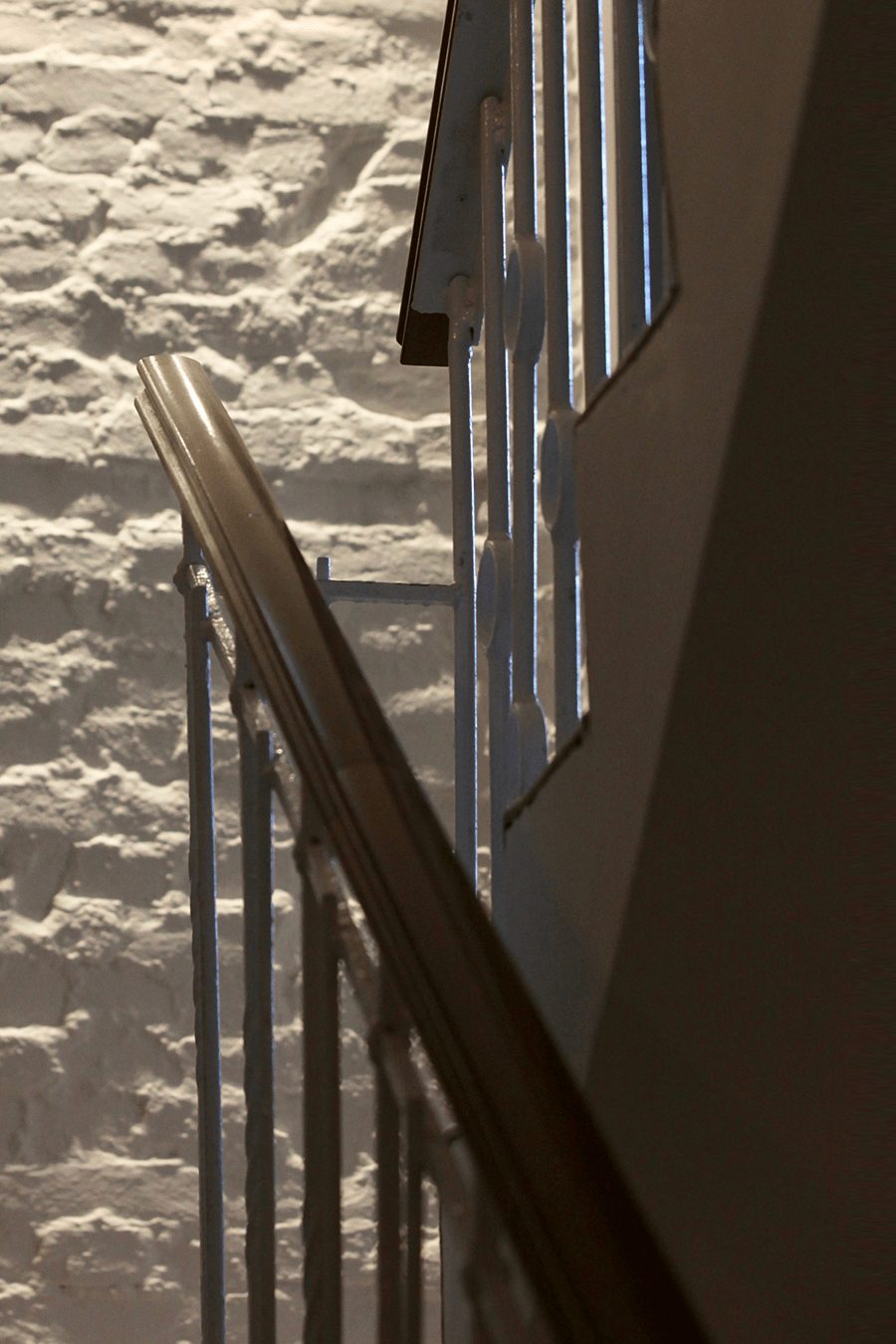 Nahaufnahme von einem Treppengeländer, das sich vor einer steinernen Wand in einem Boutique Hotel auf Usedom befindet