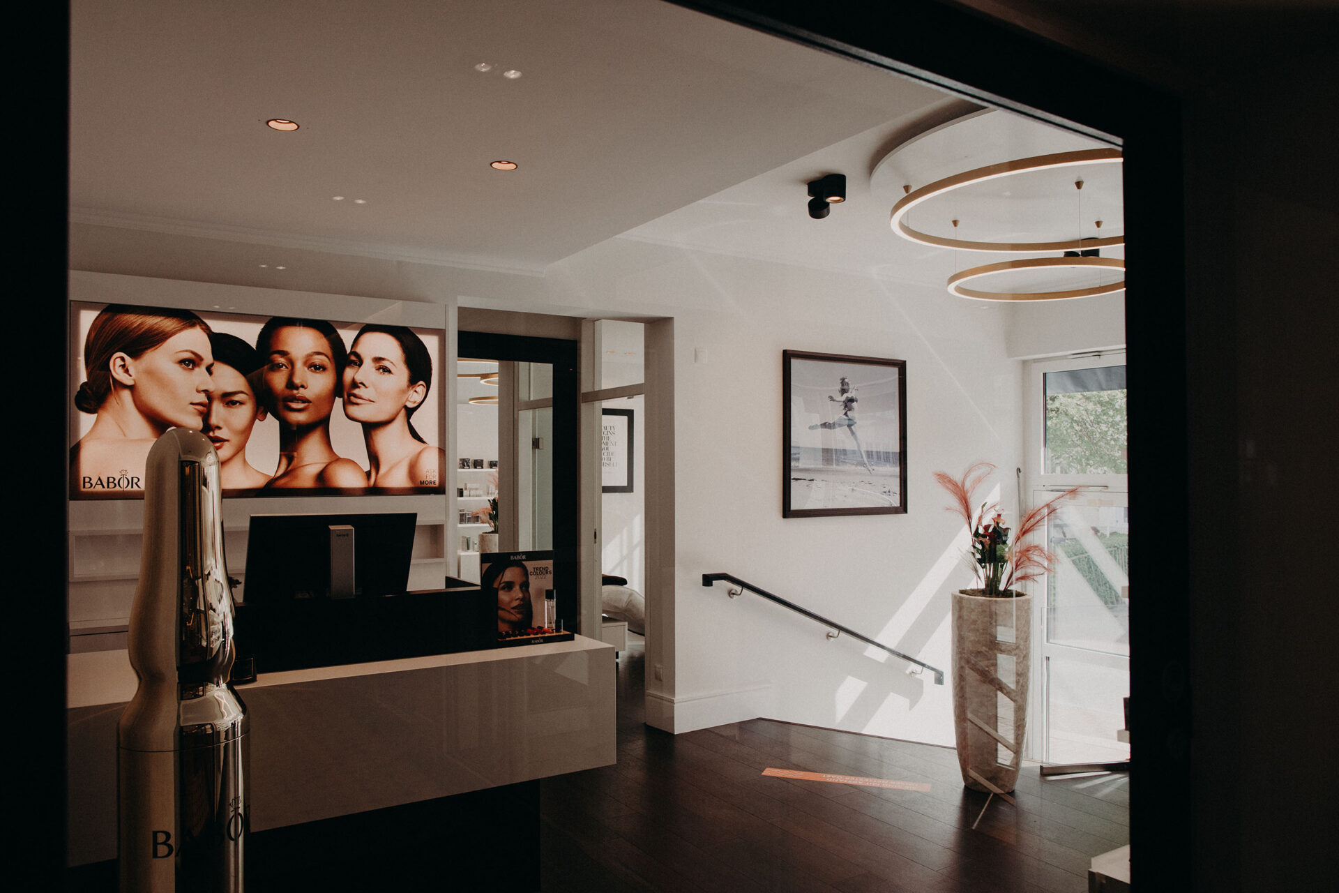 Aufnahme vom Eingang eines Beauty-Salons mit einem Empfangstresen, mehreren Bildern und großem Display vom BABOR