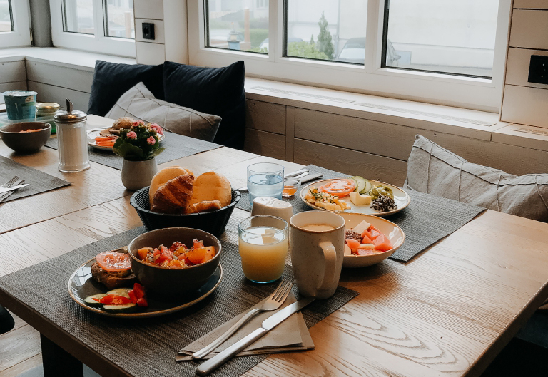 Foto von einem gedeckten Tisch, auf dem sich mehrere Teller mit leckerem Frühstück in einem Hotel in Heringsdorf befinden