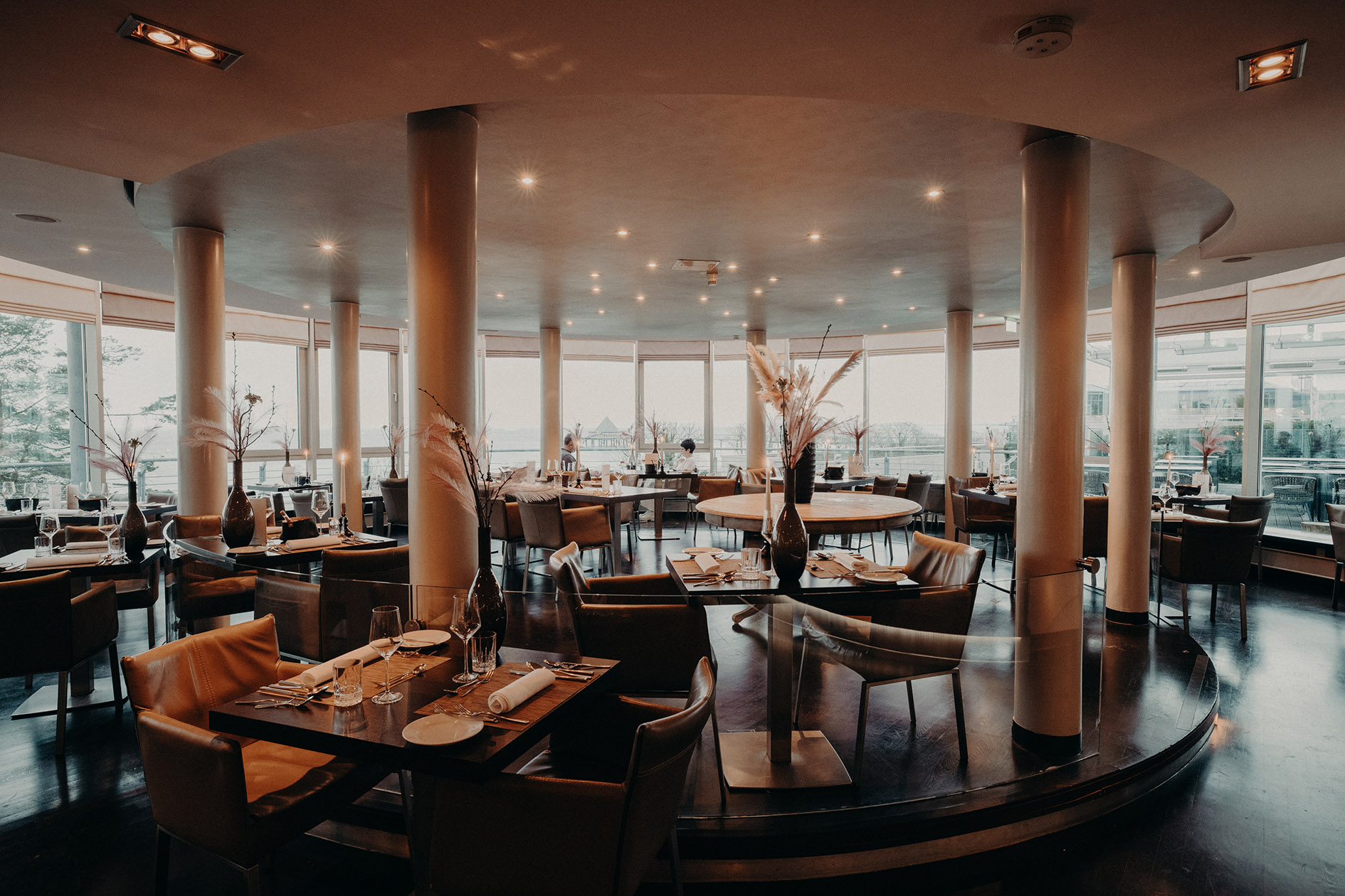 Aufnahme eines runden, von Säulen gestützten Restaurants mit gedeckten Tischen in einem Hotel mit Frühstück in Heringsdorf