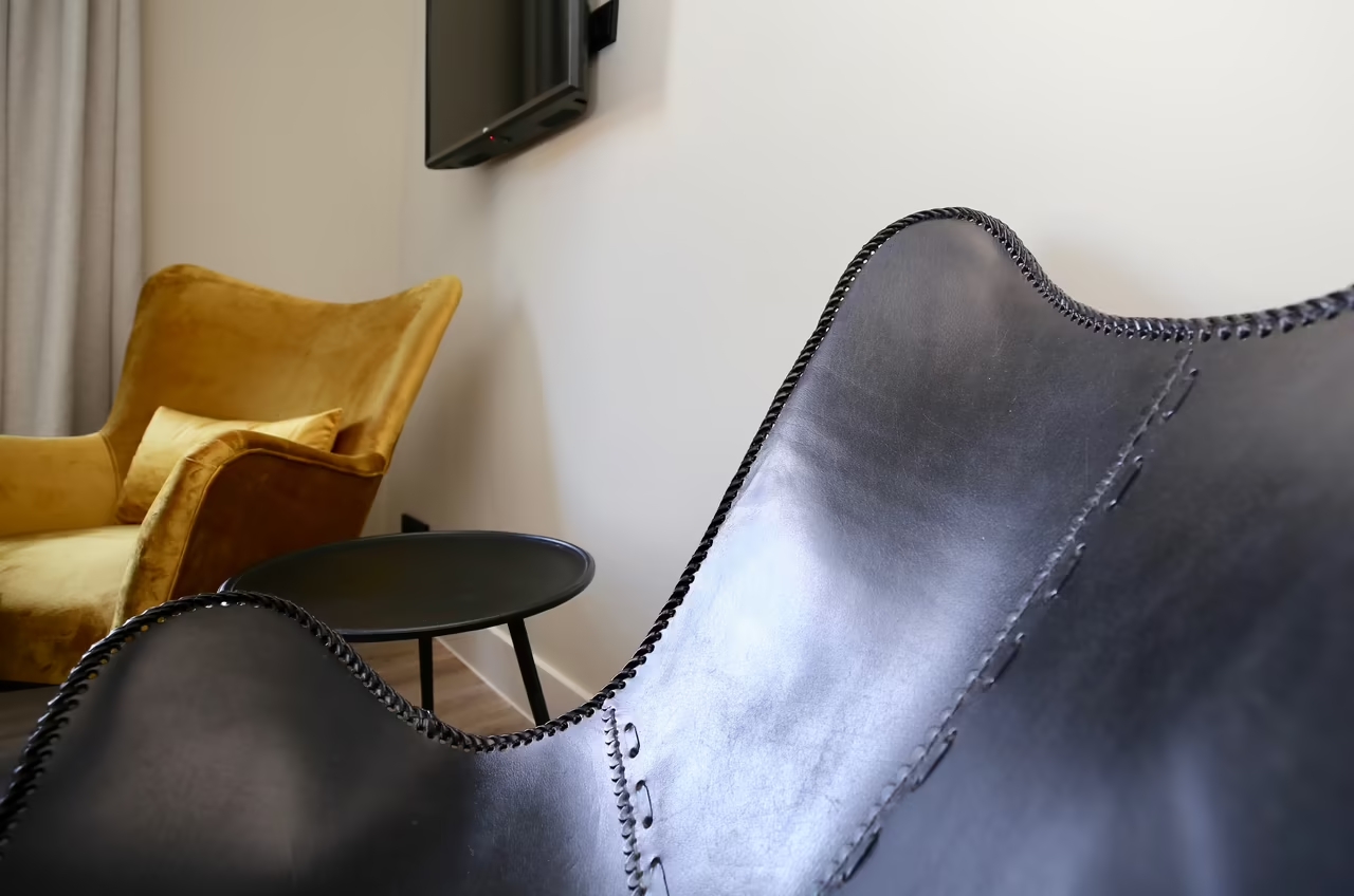 Foto eines schwarzen Ledersessels, der mit einem Tisch und einem weiteren Sessel in einem Hotelzimmer in Heringsdorf steht