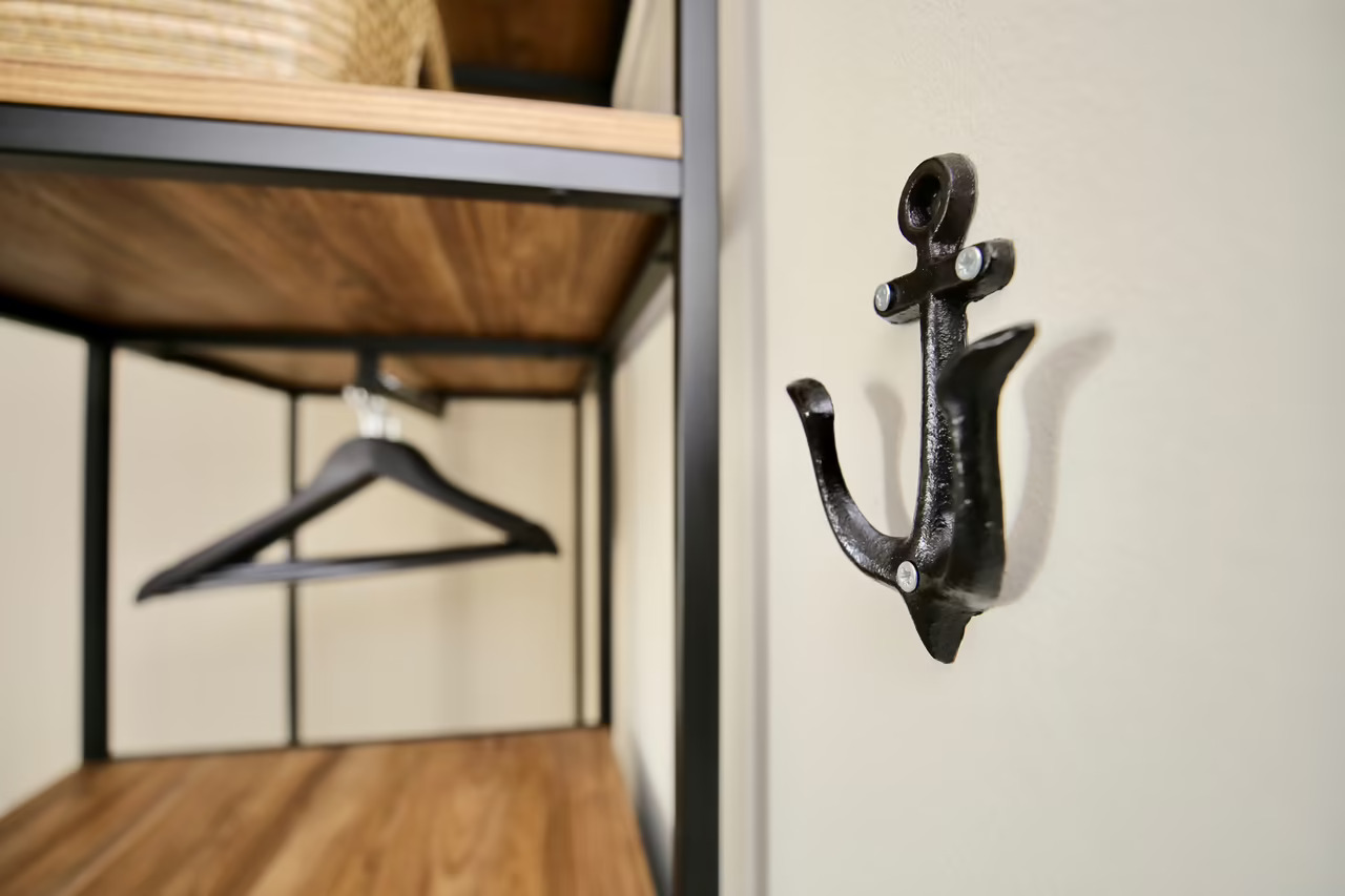 Nahaufnahme eines schwarzen, eisernen Garderobenhakens in Ankerform in einem Hotelzimmer in Heringsdorf