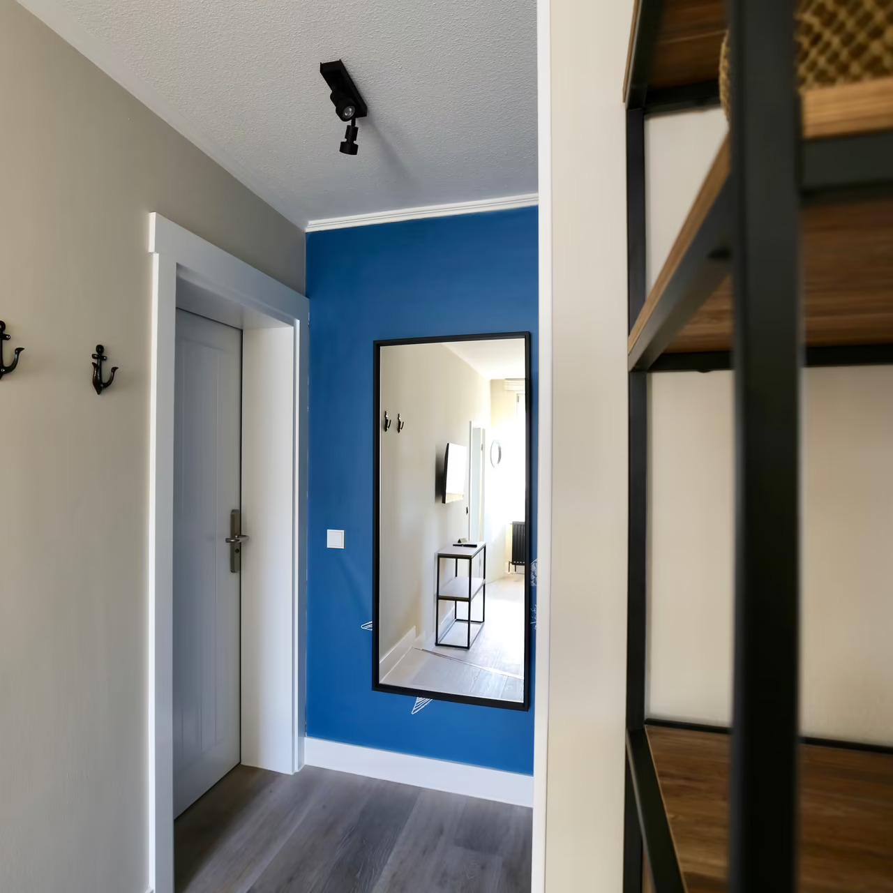 Foto von einem kleinen Flur mit einem Spiegel und Garderobenhaken in Ankerform, in einem Hotelzimmer in Heringsdorf