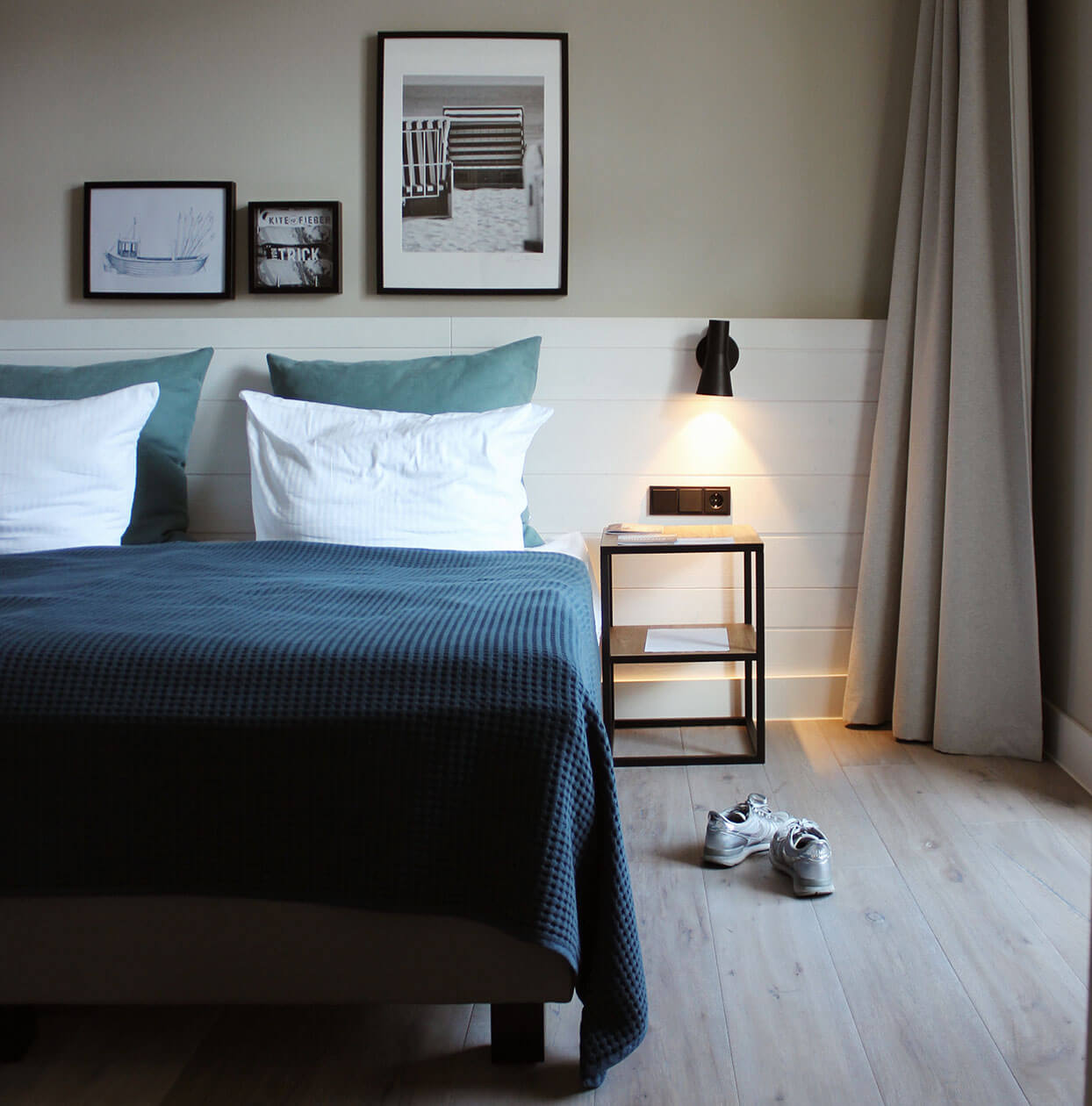 Foto von einem Hotelzimmer in Heringsdorf, zu sehen sind das Doppelbett, ein Nachtisch und Schuhpaar